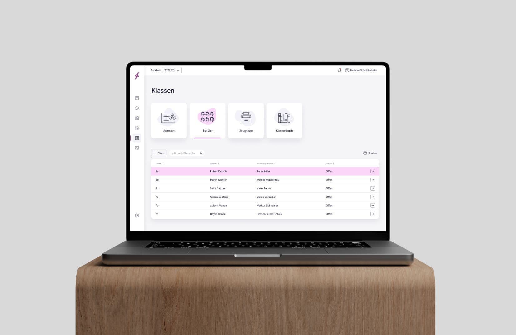 Laptop auf einem Holztisch zeigt eine Klassenverwaltungssoftware